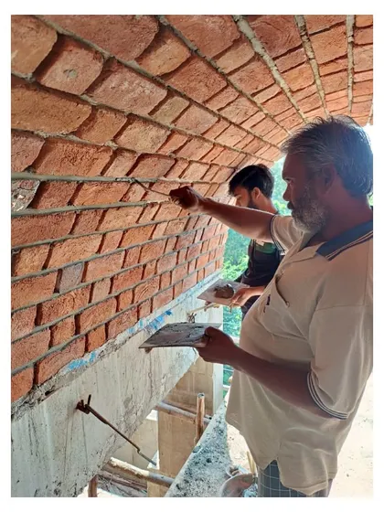 A craftsman performs recessed grouting on the brick vault, a meticulous process that highlights the texture and pattern of each individual brick.
