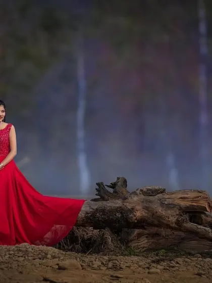 A stylish pre-wedding portrait with the couple posed against a dramatic, moody backdrop. The bride's flowing red gown adds a vibrant pop of color to this cinematic shot.