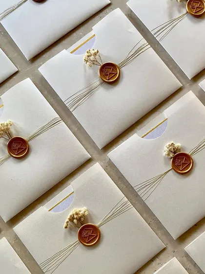 These beautiful flat envelopes were created for a private home ceremony. The design is minimal and elegant, featuring a simple thread wrap, a custom wax seal, and a tiny sprig of dried flowers.