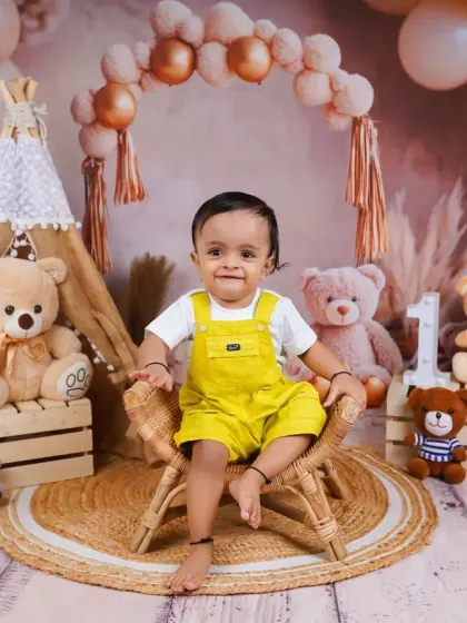 A similar boho theme with a different color palette. This little boy in his bright yellow overalls looks absolutely adorable among the teddy bears.