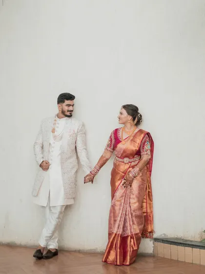 A beautiful wedding day portrait of the couple. The bride's traditional Maharashtrian look, with her silk saree and gold jewelry, perfectly complements the groom's elegant sherwani.
