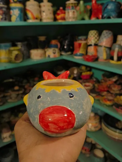 A close up of a brightly painted pot, showing the glossy finish and vibrant colours you can achieve with our materials.