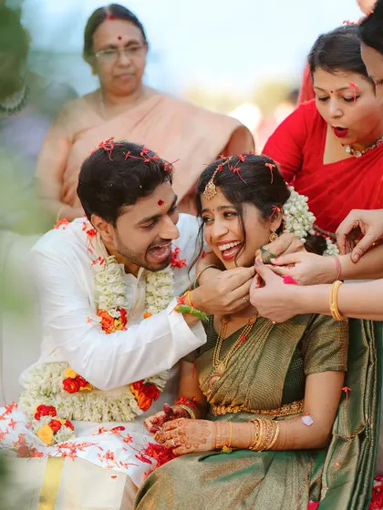 A moment of pure, unadulterated laughter during a wedding ritual. This candid shot perfectly captures the fun and joy that family and traditions bring to the celebration.