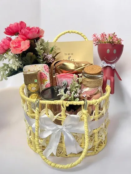 Another one of our Rakhi hampers, this time presented in a cute yellow woven bag. It's filled with flowers, a personalized card, and other treats, making it a perfect gift for a sister.