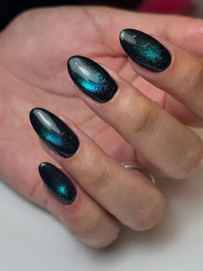 A palette reminiscent of the night sky. This galaxy-like effect is created with a deep blue and green magnetic cat-eye polish over a black base.