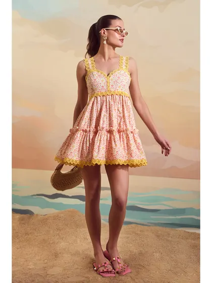 A full-length shot of the Schiffli Sailor Dress from Qala Clothing, styled with a woven bag and sunglasses for a complete summer look.