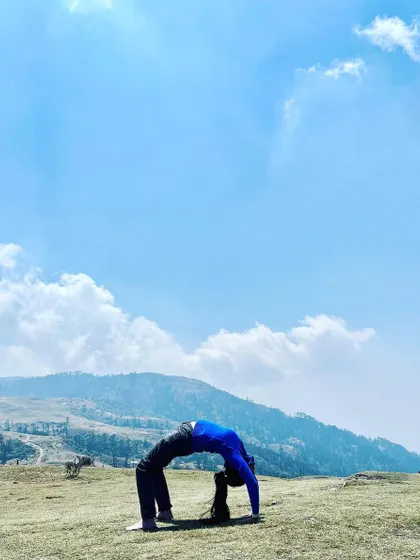 A full wheel pose, Chakrasana, on the Sandakphu trail. After a long hike, this deep backbend feels incredible, releasing tension in the spine and opening the heart to the vast sky.