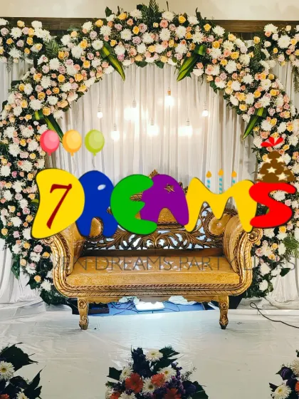 A popular choice for wedding receptions, this stage combines a beautiful arch of white and peach flowers with trendy hanging bulbs. The lighting creates a warm and celebratory atmosphere for the evening.