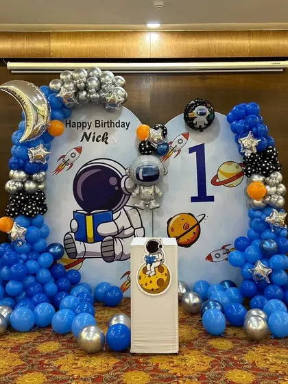 The full astronaut decoration, showing the balloon columns and floor balloons that create an immersive space environment.