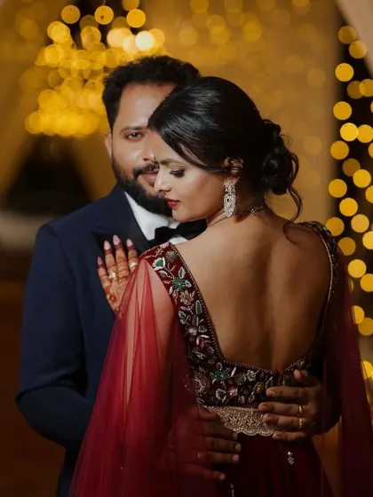 An elegant reception portrait with a focus on the bride's stunning backless blouse and the groom's gentle embrace. We use creative angles to highlight the details of your outfits and your connection.