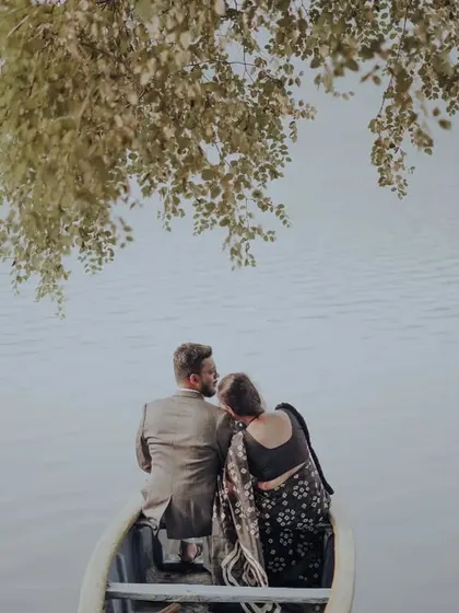 An intimate overhead shot of the couple in a boat, framed by leaves to create a private and romantic feeling.