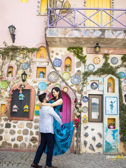 A romantic shot of the groom lifting his bride in front of a colorful, European-style building, creating a destination-like feel.