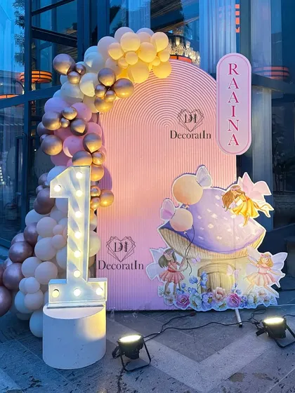 A close-up of the photo corner with the marquee '1' and the charming fairy house prop, beautifully lit for evening photos.