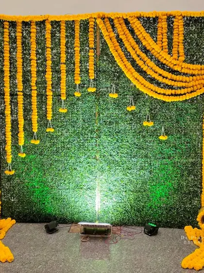 A duplicate image of the green grass mat backdrop with hanging marigold strings.