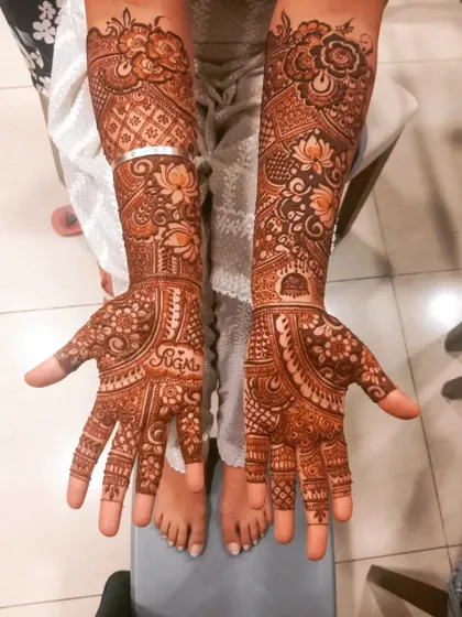 A beautiful Karwachauth mehndi for a lovely client. The design is a mix of floral and traditional patterns, with the name 'Sugal' personalized on the palm.