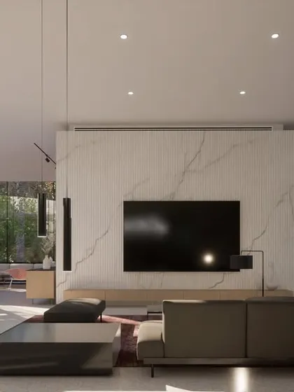 The living room of the Hyderabad residence, where a curved glass wall offers panoramic views of the interior courtyard and spiral staircase. The interior palette of white marble and neutral tones emphasizes natural light and keeps the focus on the outdoor scenery.