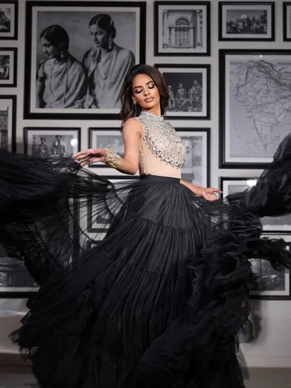 A full-length shot showing the drama and movement of the black tulle skirt. The makeup is bold and confident.