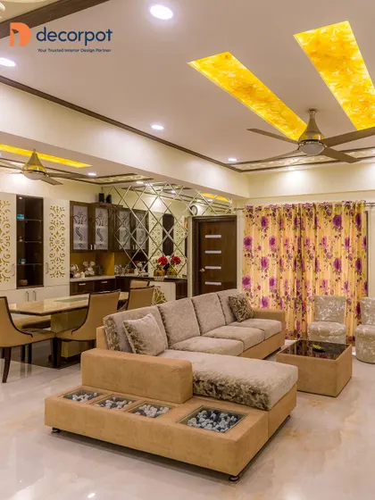 This luxurious dining area features a large L-shaped sofa and a custom crockery unit with mirrored panels, creating a glamorous space for entertaining.