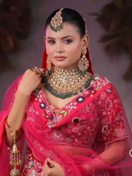 A powerful bridal portrait created by one of our students. The makeup features a pop of pink on the eyes, complementing the pink and green of the lehenga.