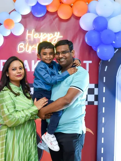 A happy family portrait taken at a car-themed fifth birthday party. We capture both posed and candid shots of the birthday child with their parents.