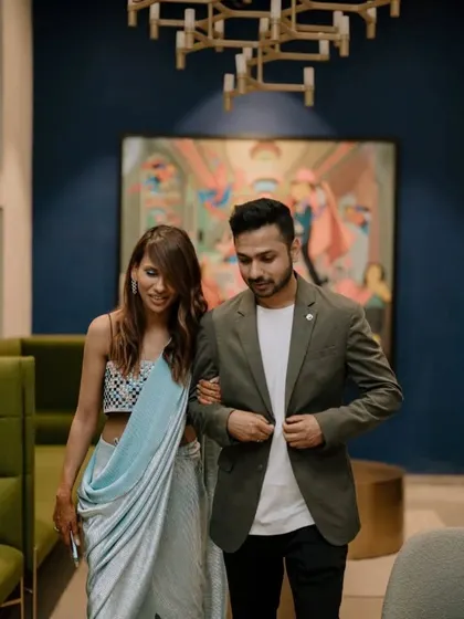 A stylish couple enjoying a quiet moment during their cocktail party. The modern interior with artistic decor provides a sophisticated backdrop for the event.