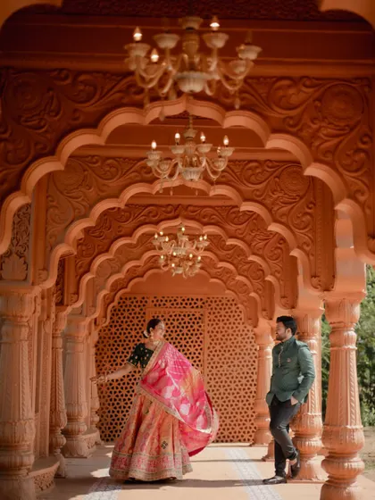 A beautiful shot from a pre-wedding session at a heritage location, with the bride twirling in her lehenga in a stunning arched corridor.