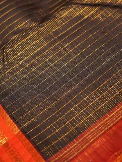 The fine gold zari checks on the black body add a subtle shimmer to this elegant saree.
