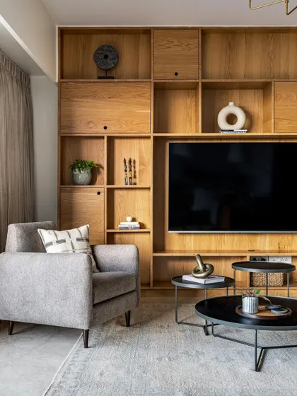 This family room features a full wall of custom oak shelving, providing ample storage and a beautiful display area around the TV.