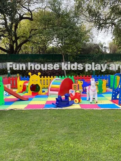 Our rainbow play area set up in a large park for a birthday party, complete with a trampoline and plenty of space for kids to run.