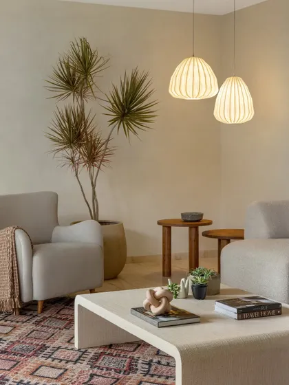 These paper lantern-style pendants add a soft, diffused light to this living room, enhancing its warm and minimal aesthetic.