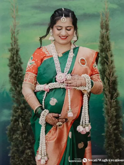A moment of reflection. The layered floral necklace and matching maang tikka create a cohesive and elegant look.