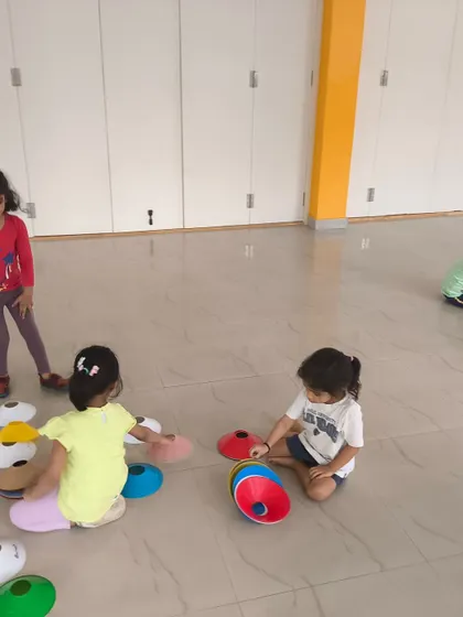 A game of sorting and stacking cones is a fun way we teach colors, counting, and fine motor skills during our indoor athletics classes for toddlers.