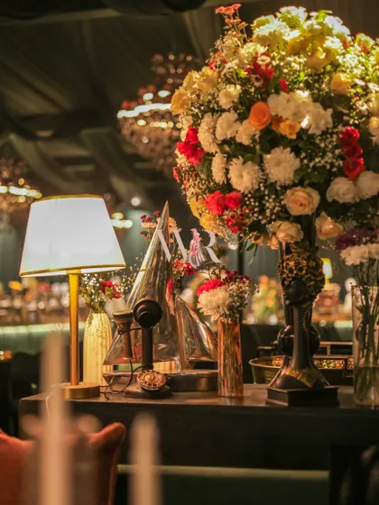 A similar shot to image 9, this time with a slightly different angle, showcasing the beautiful textures of the flowers and the warm light from the lamp.
