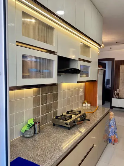 A close-up of the fluted glass cabinets and the profile lighting. These details give the kitchen a premium and modern look.
