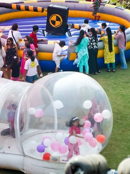 A transparent inflatable bubble house filled with balloons, creating a magical and photo-worthy play space for children.