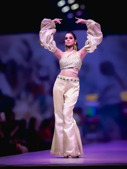 A powerful pose on the runway. The unique puffed sleeves and flared pants create a striking silhouette, and my focus was to freeze that dynamic movement, showcasing the designer's creative vision.