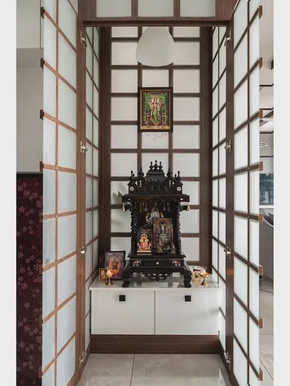 The puja space opened, revealing the serene interior. The design provides seclusion without sacrificing a sense of openness.
