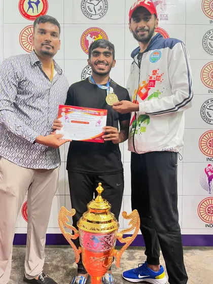 This fighter's smile says it all. Holding his gold medal and certificate at the Karnataka State Kickboxing Championship, standing by the team trophy.