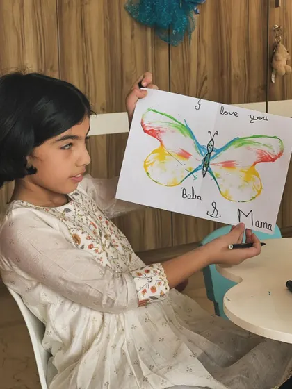 A beautiful butterfly created with our rope painting technique. The child is adding a sweet message for her parents, turning her art into a heartfelt gift.