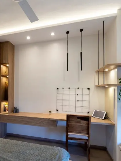 This bedroom features a long, floating study desk with integrated storage and suspended open shelving, creating a functional and stylish workspace.