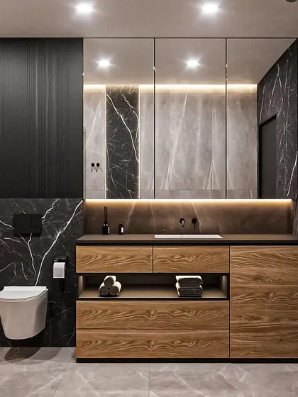 A sleek and moody bathroom with black marble walls and a floating wooden vanity. The backlit mirror and under-vanity lighting create a sophisticated, high-end hotel vibe.