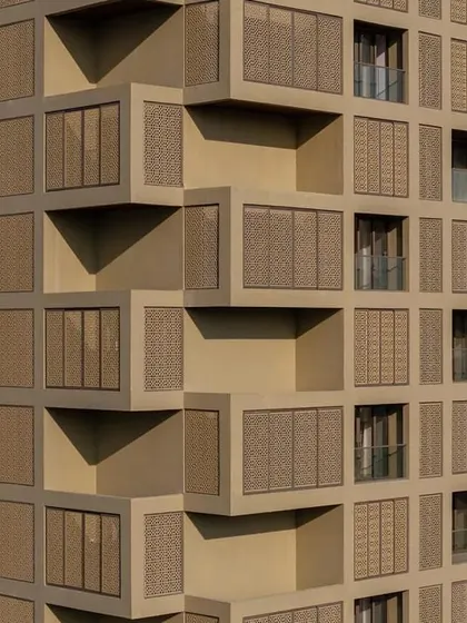 The intricate pattern of the facade on 'SCREEN 504'. The design not only reduces heat gain but also casts dynamic shadows, adding texture and depth to the building's exterior.