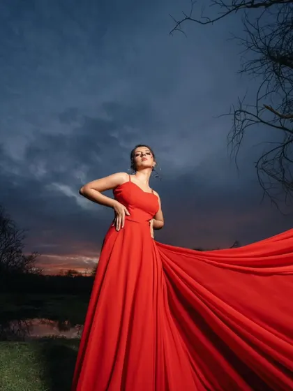 A moment of pure drama and beauty. The way this red trail gown catches the light against the dark sky is perfect for creating a powerful and artistic pre-wedding photograph.
