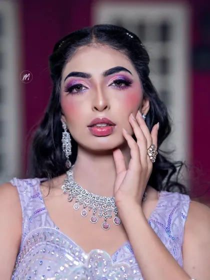 A bold and artistic party look with a focus on the eyes. The purple graphic eyeshadow is a statement, balanced with glowing skin and a glossy lip.