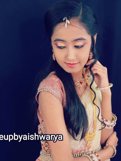 A beautiful, traditional look for a young model. The eye makeup features a sunset-inspired blend of yellow and pink, paired with a simple lip and traditional jewelry.