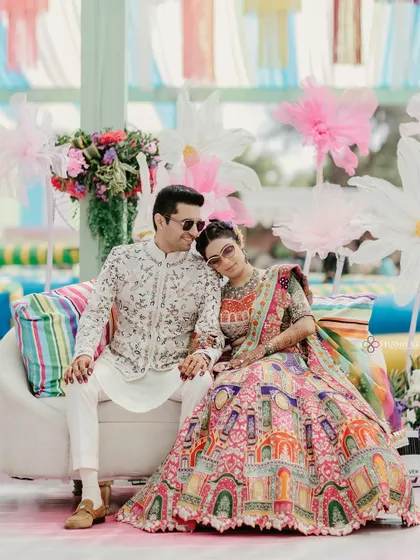 A relaxed portrait of the couple, in their colorful Mehendi outfits, looking cool and happy.