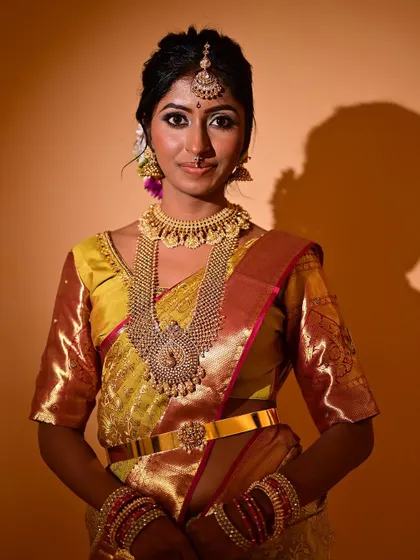 A frontal portrait of the traditional Iyengar bride. The makeup is perfectly symmetrical, with attention to the bindi placement and the sharp definition of the eyes and lips, which is key for traditional bridal looks.