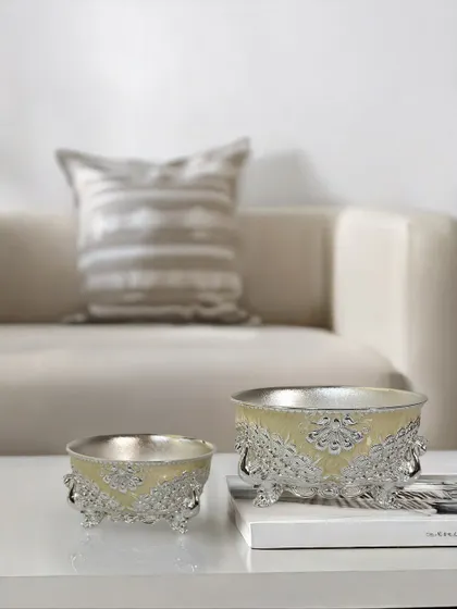 A touch of artistry, a hint of shine. My enamel bowl with engraved peacock stands, featured in a delicate buttercup yellow, is a keepsake you will cherish. Perfect for festive gifting.