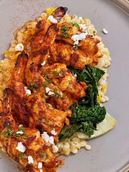 A top-down view of the Smoked Chili Grilled Prawns, showing the vibrant colors of the dish and the creamy texture of the barley risotto.