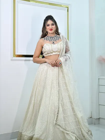 A full front view of the ivory chikankari lehenga, complete with a sheer embellished dupatta.